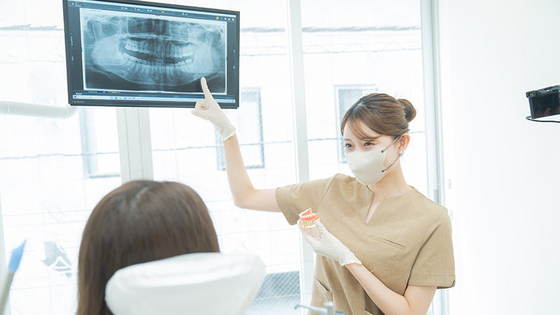 カウンセリングで患者と歯科医師が口腔状態を確認している場面